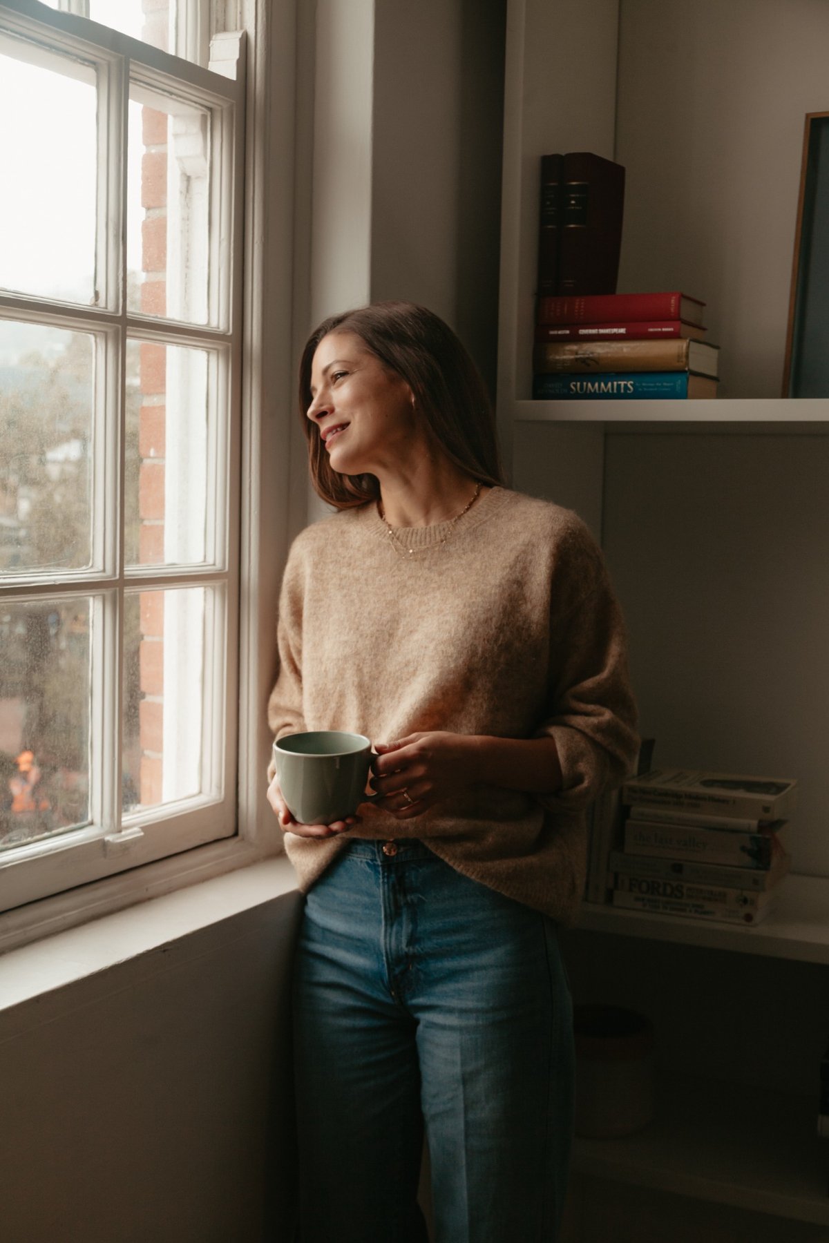 Nina Zomaia mit Tasse am Fenster